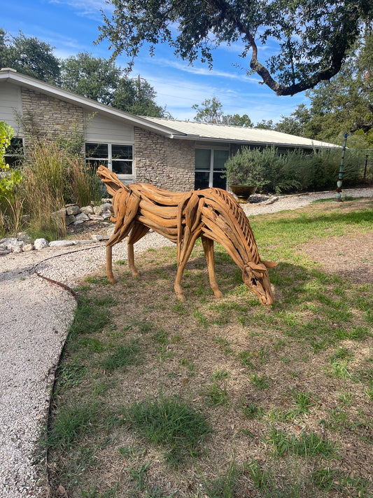 Life sized sculpture of a grazing horse swatting flies with its tail