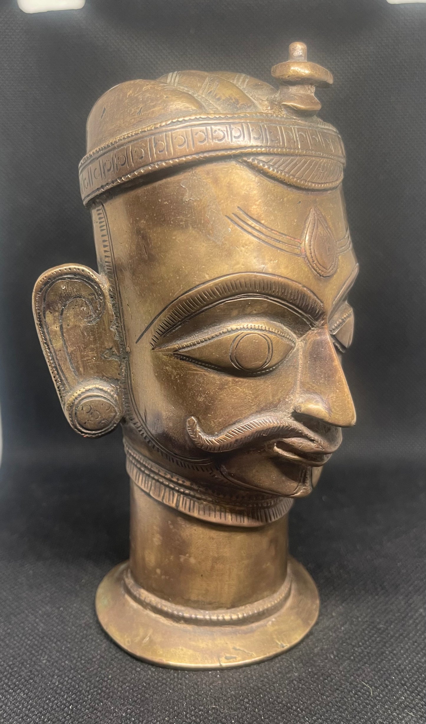 Antique Mukhalinga, depiction of Lord Shiva with beautiful turban,topped by a Linga and sitting on a rare attached base.