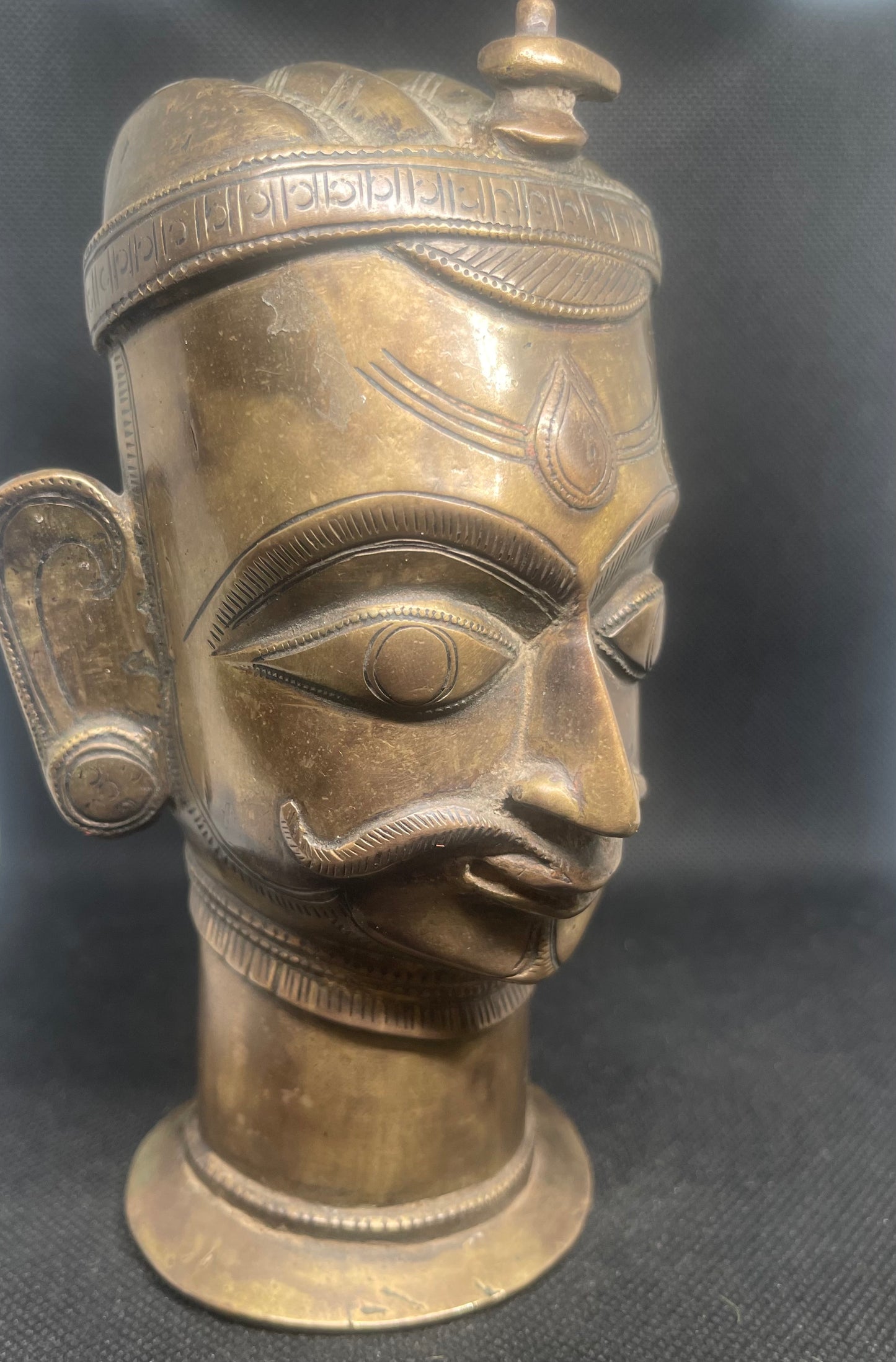 Antique Mukhalinga, depiction of Lord Shiva with beautiful turban,topped by a Linga and sitting on a rare attached base.