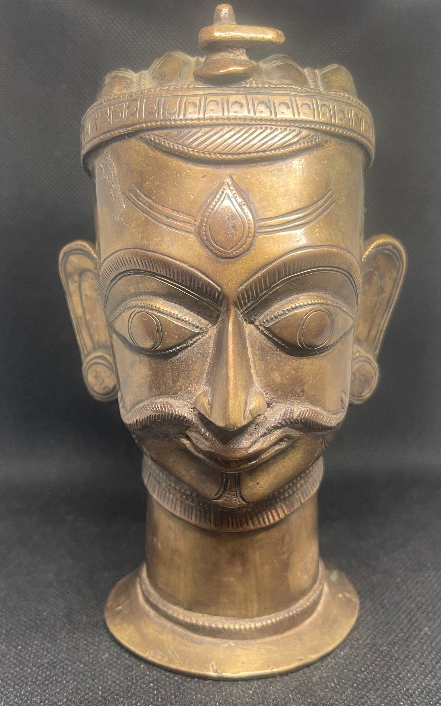 Antique Mukhalinga, depiction of Lord Shiva with beautiful turban,topped by a Linga and sitting on a rare attached base.