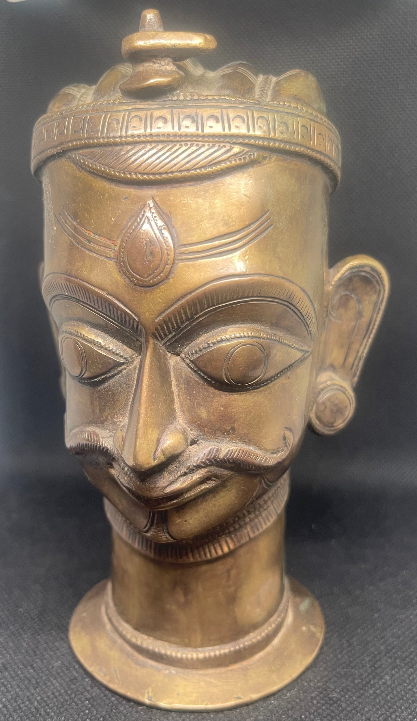 Antique Mukhalinga, depiction of Lord Shiva with beautiful turban,topped by a Linga and sitting on a rare attached base.